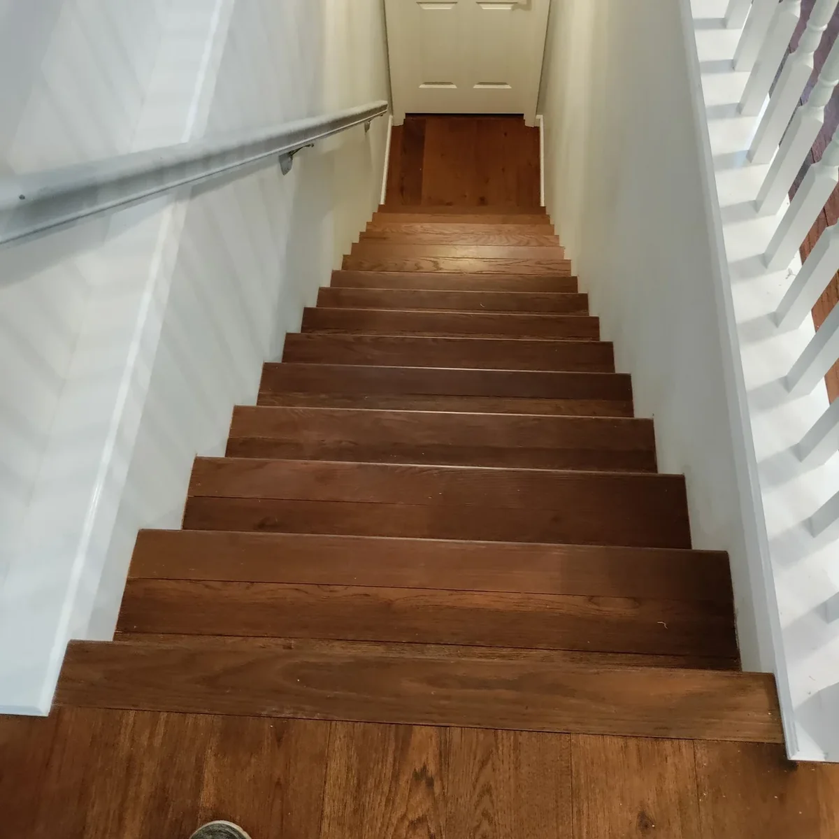 Dark stained hardwood stair treads with white painted risers